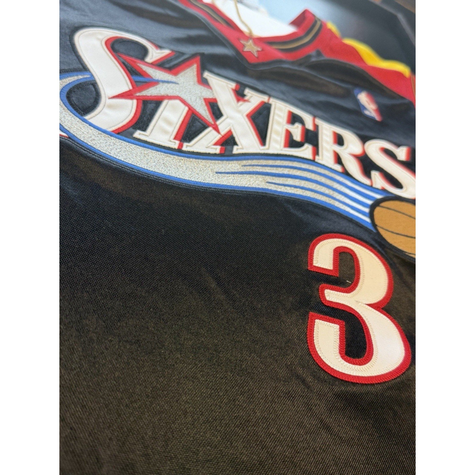 Close-up of Allen Iverson signature on Philadelphia 76ers Black Alternate Hardwood Classics jersey