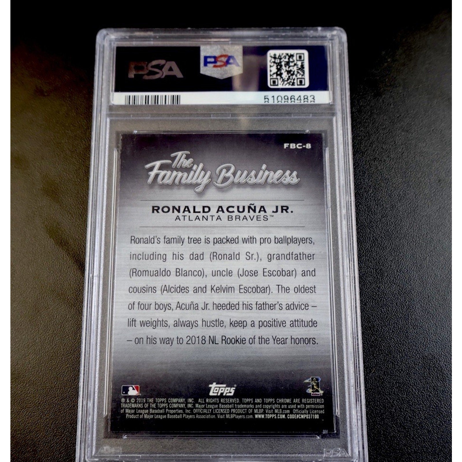Baseball card back with 'The Family Business' text and PSA grading label.