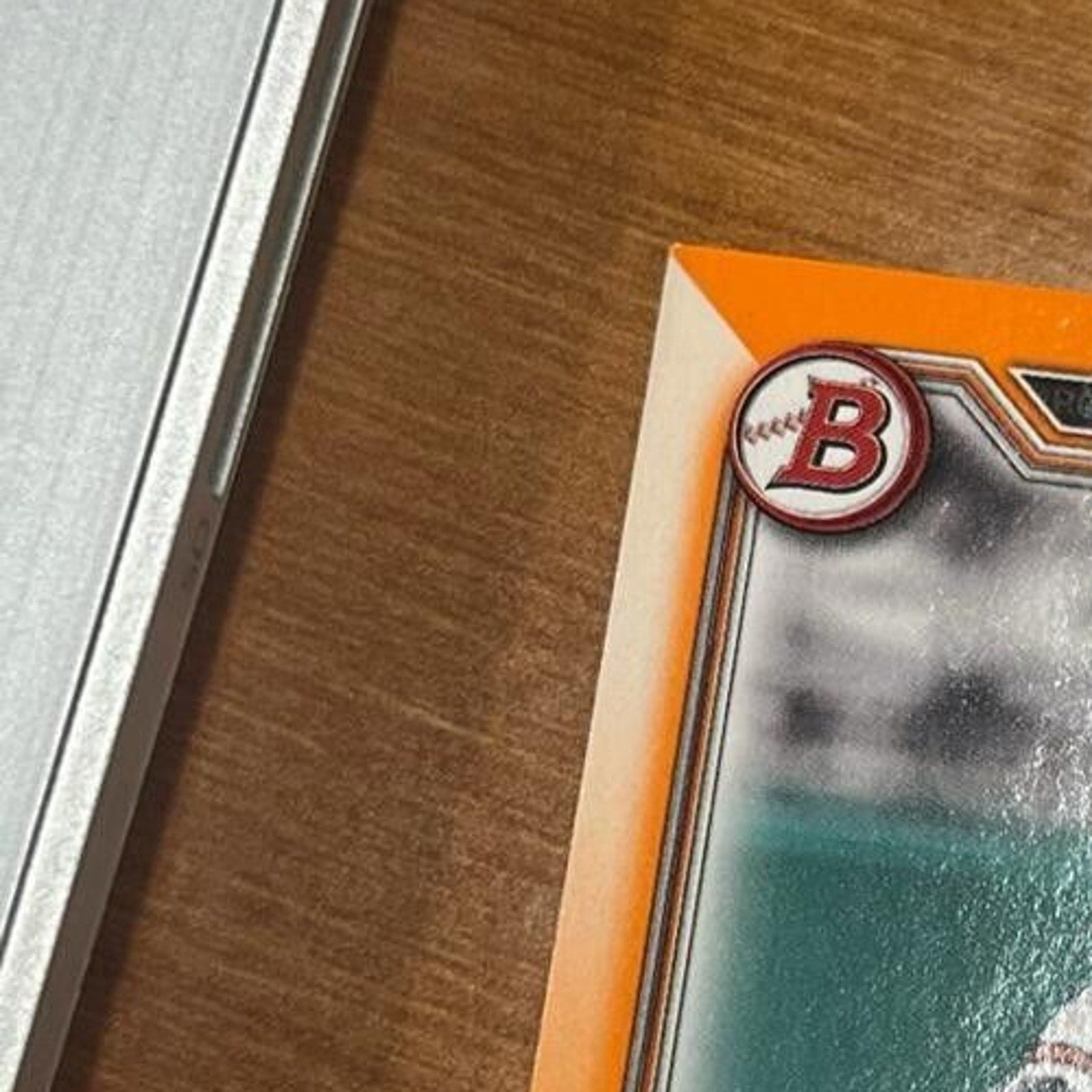 Top edge close-up of 2021 Bowman Draft Connor Norby Orange Refractor baseball card