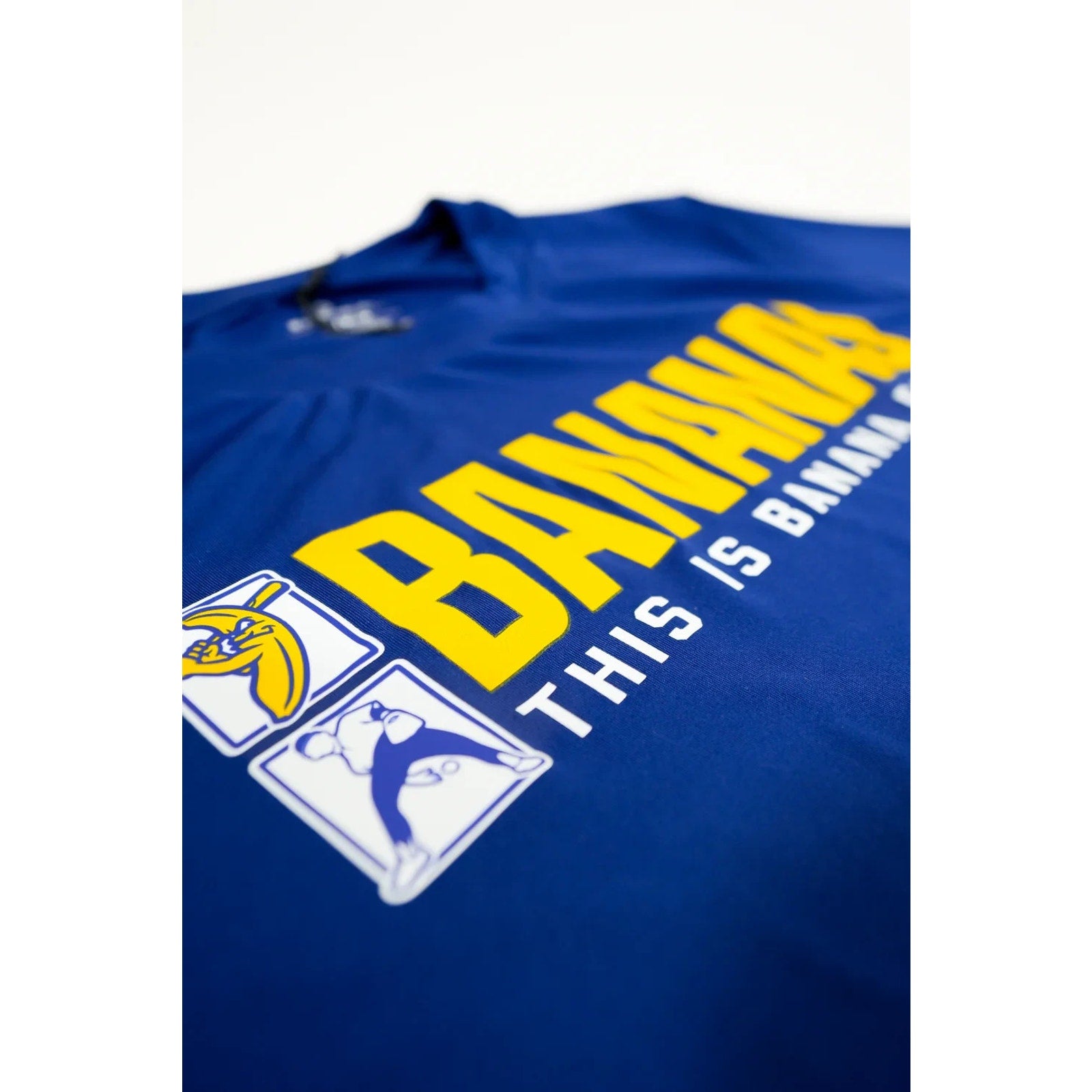 Close-up angled view of Savannah Bananas “This Is Banana Ball” front graphic on blue tech tee