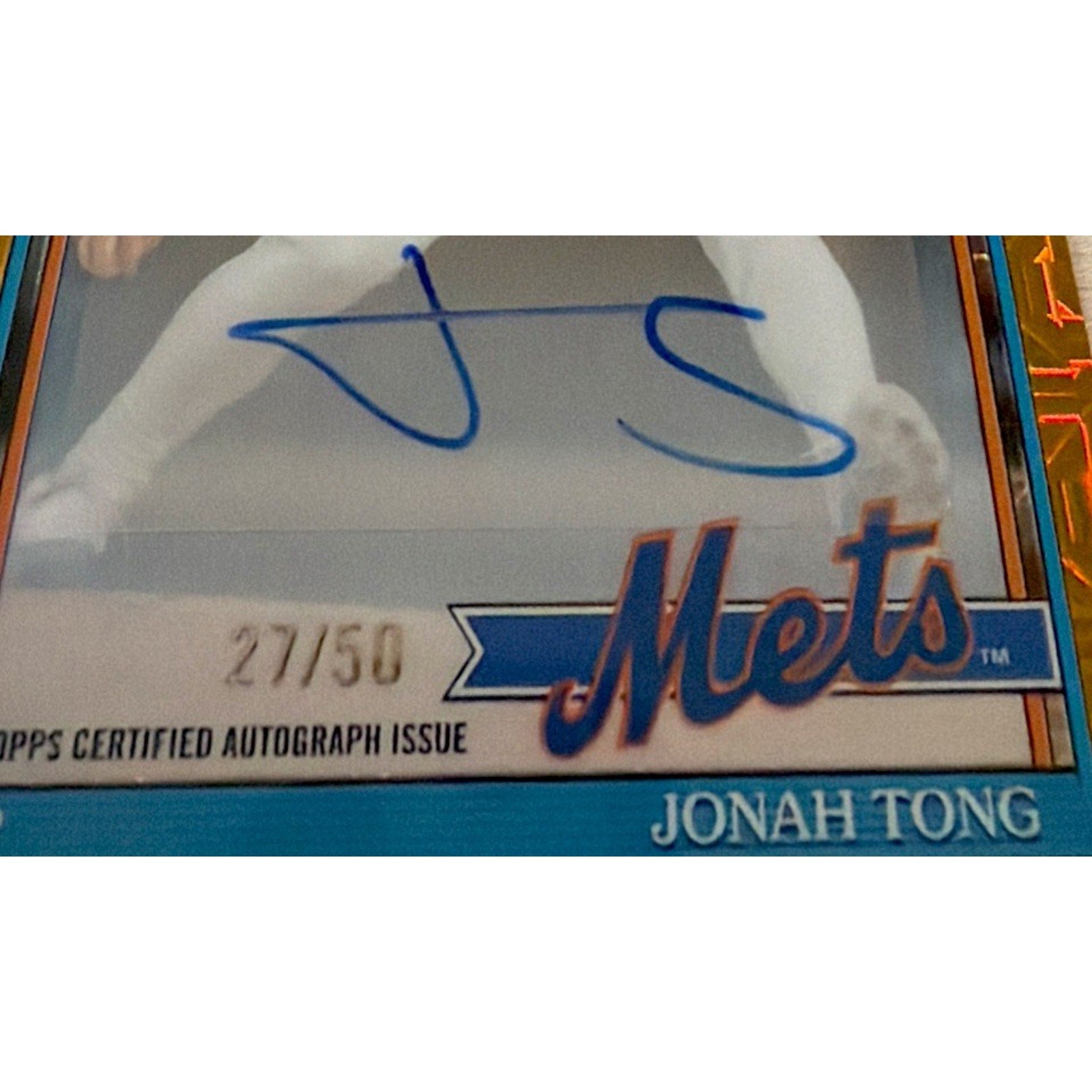 Close-up autograph section of Jonah Tong rookie auto card with blue ink signature and serial numbering 27/50