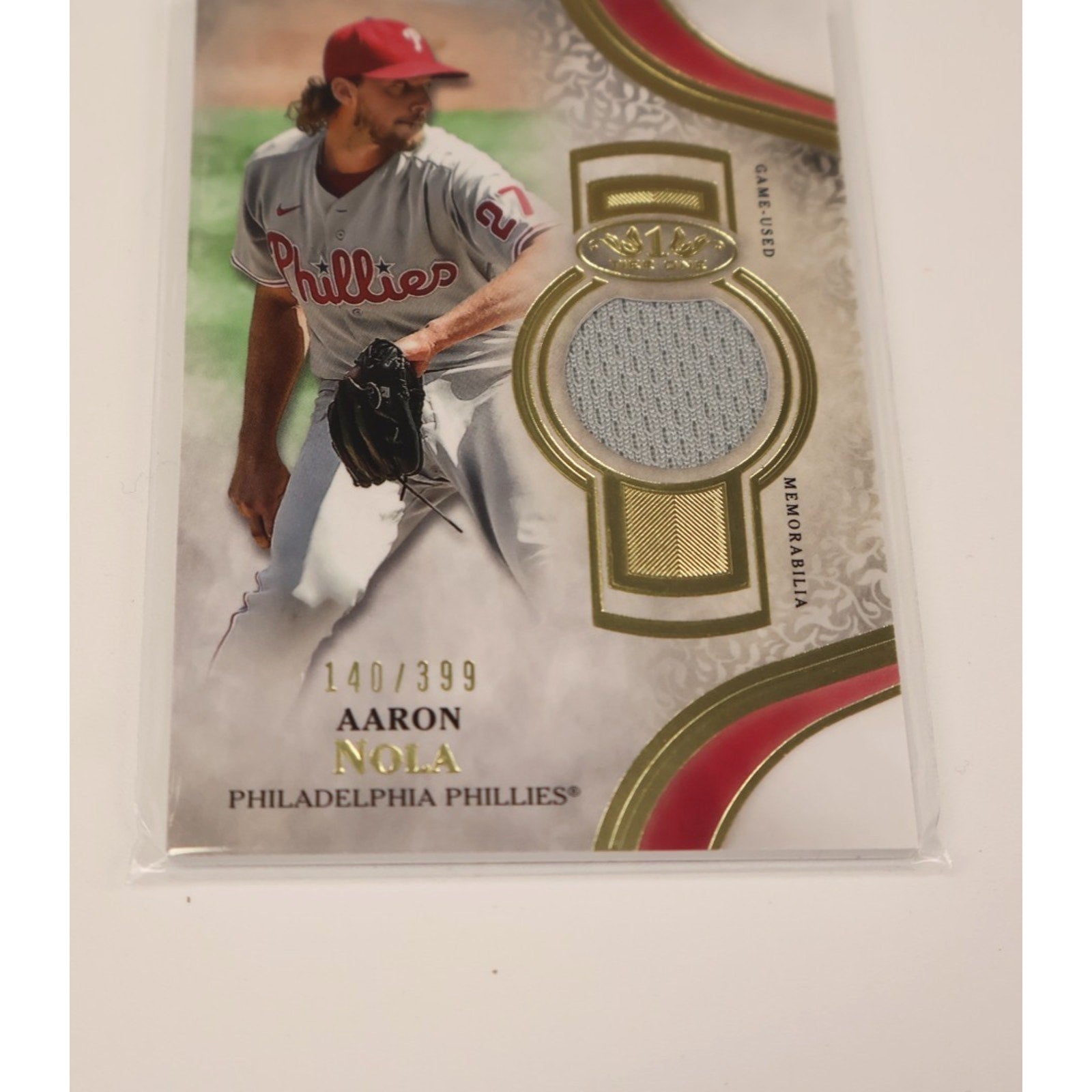 Angled front view of Aaron Nola 2021 Topps Tier One memorabilia card featuring certified game-used relic