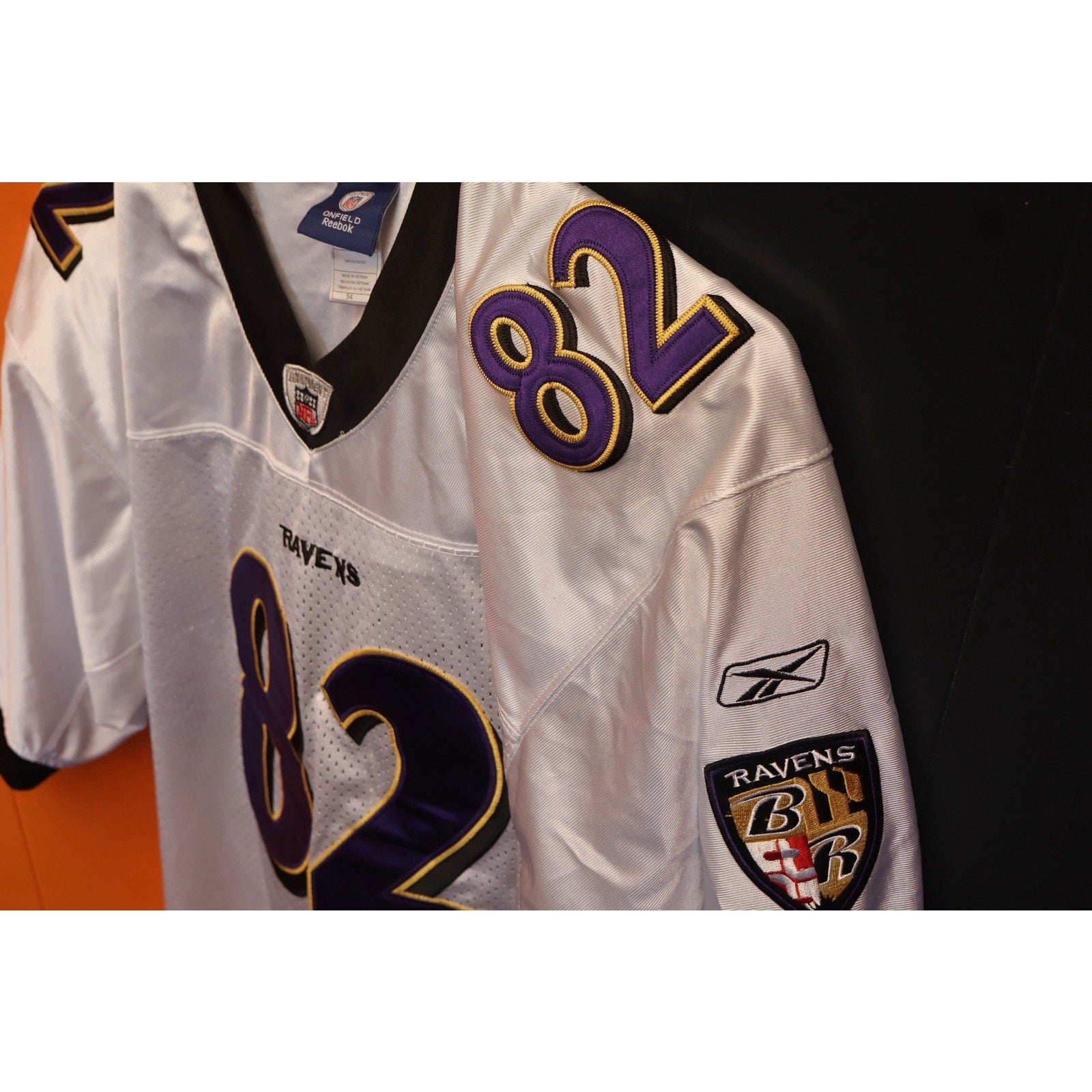 White sports jersey with number 82 and Ravens logo on a black background
