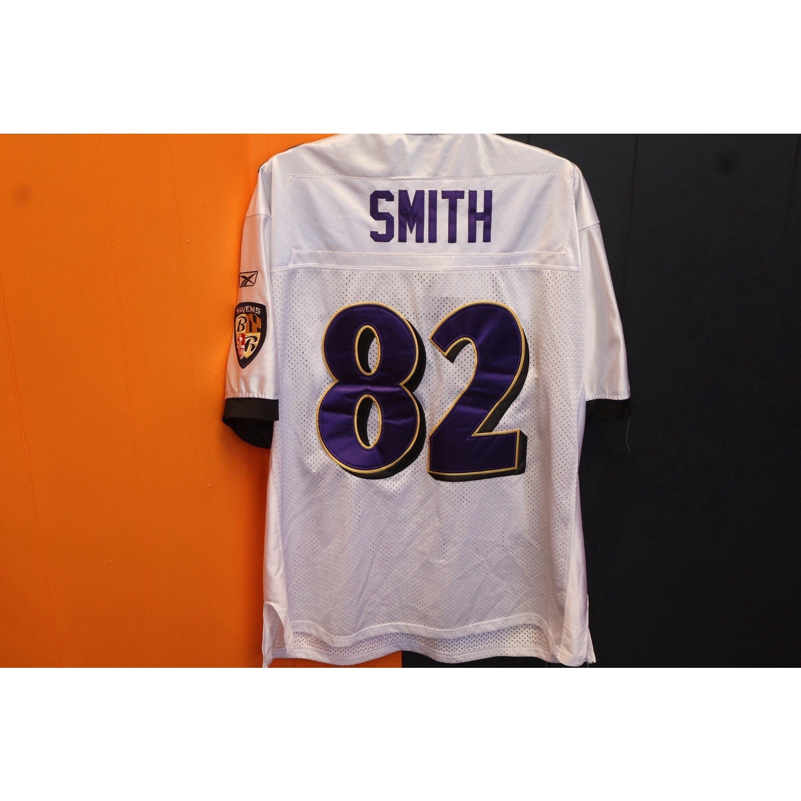 White sports jersey with 'Smith' and number '82' on a black and orange background