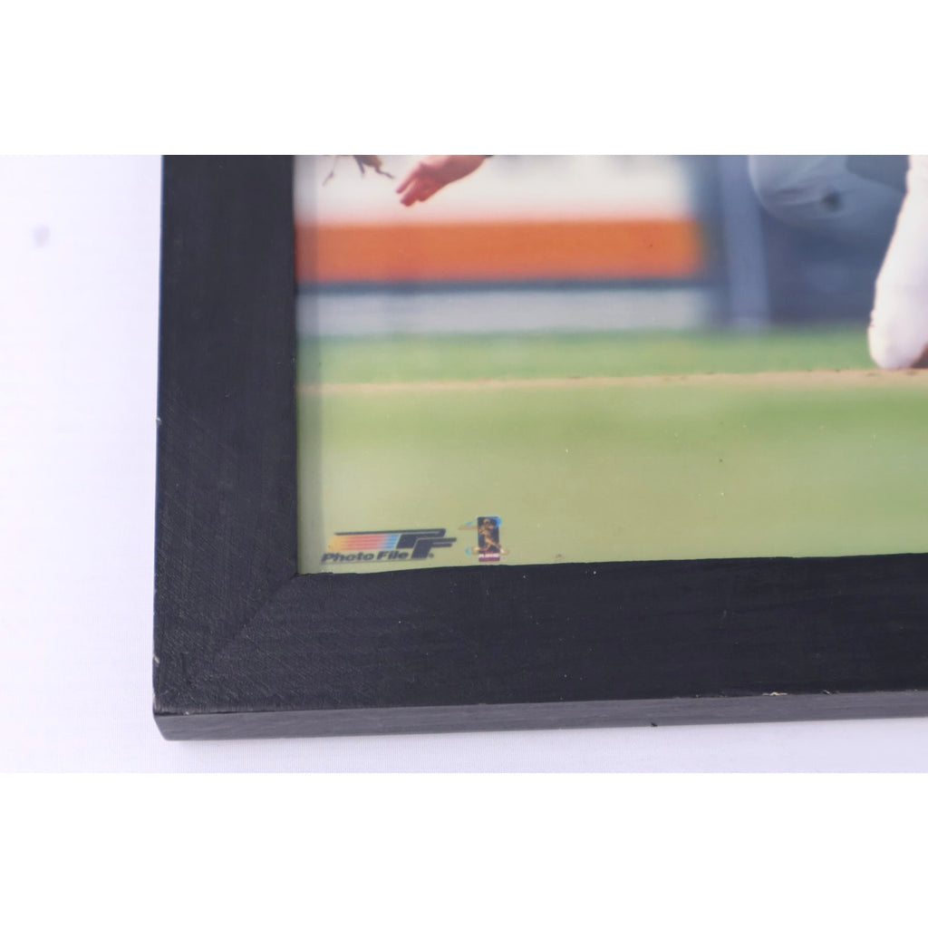 Side profile of black wooden frame containing Cal Ripken Jr action image