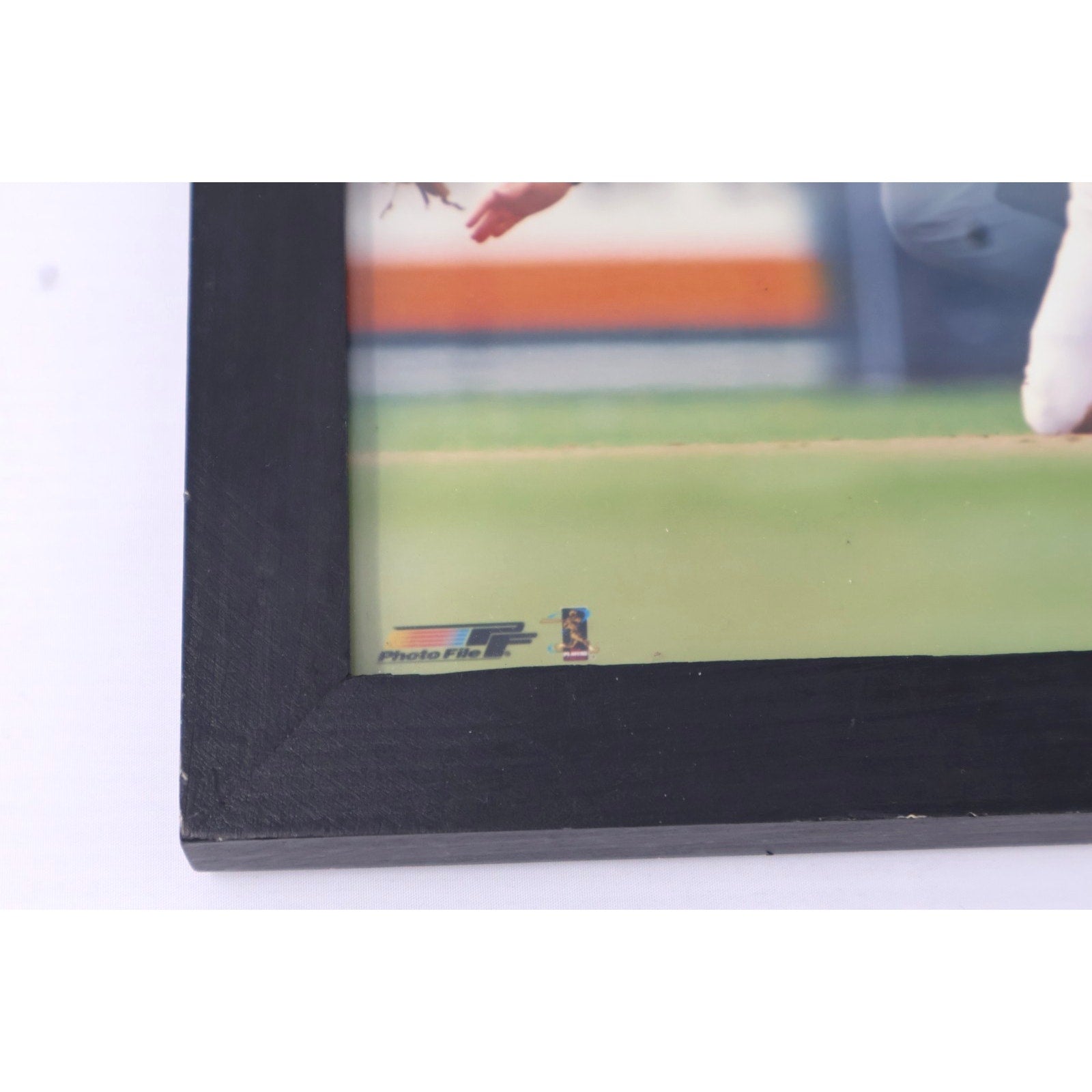Side profile of black wooden frame containing Cal Ripken Jr action image