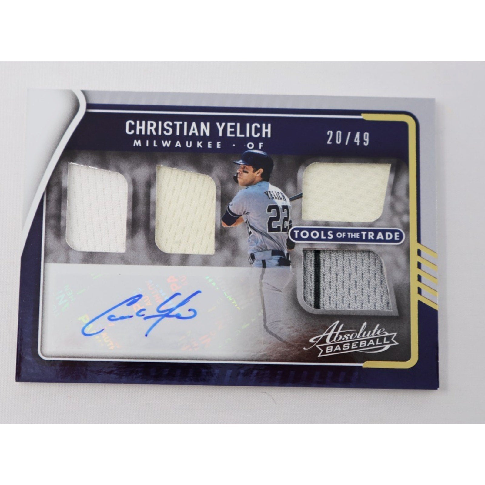 2022 Panini Absolute Christian Yelich Tools of the Trade autograph card with four jersey swatches numbered 49
