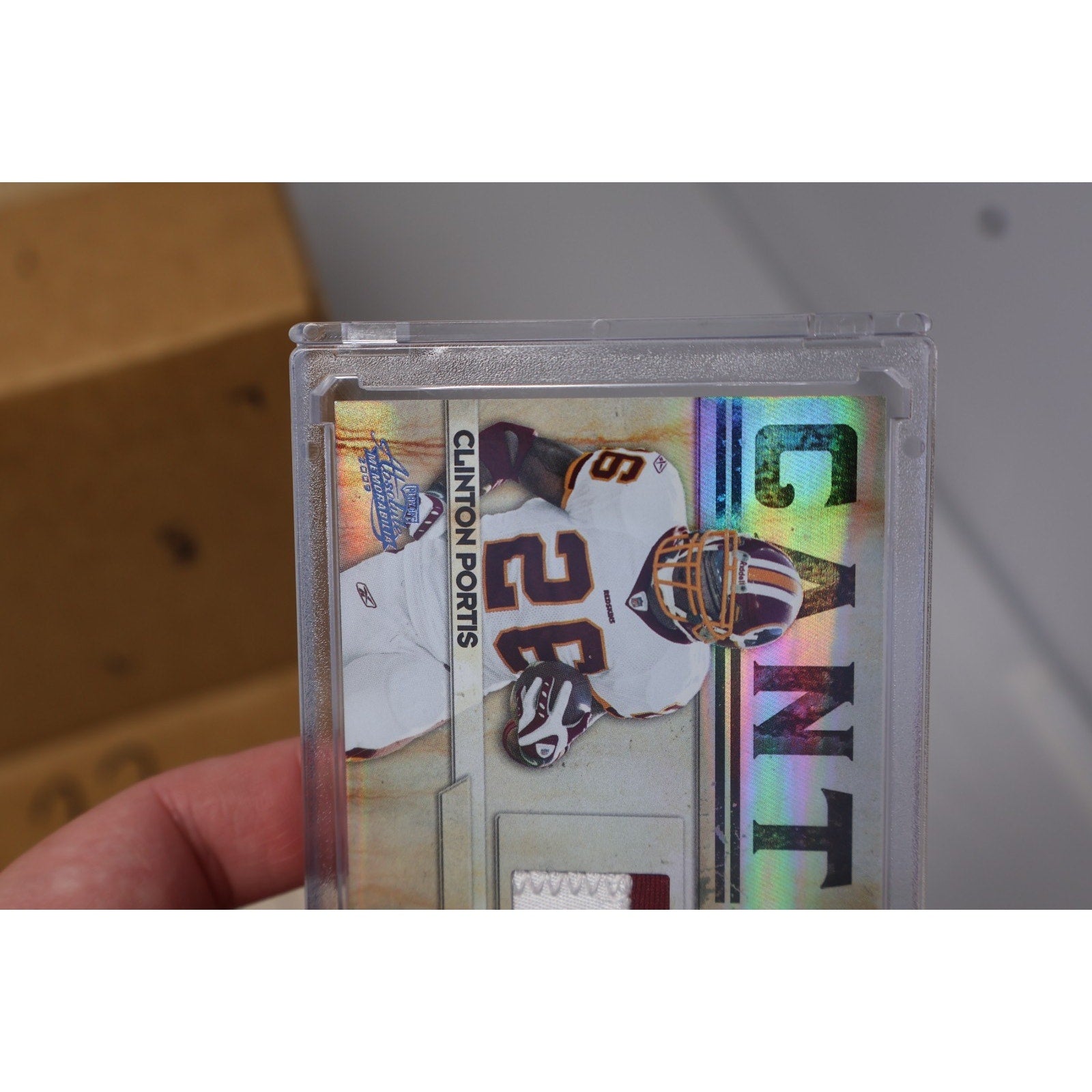 Side angle view of Clinton Portis 2009 Panini Absolute jersey relic football card in protective holder