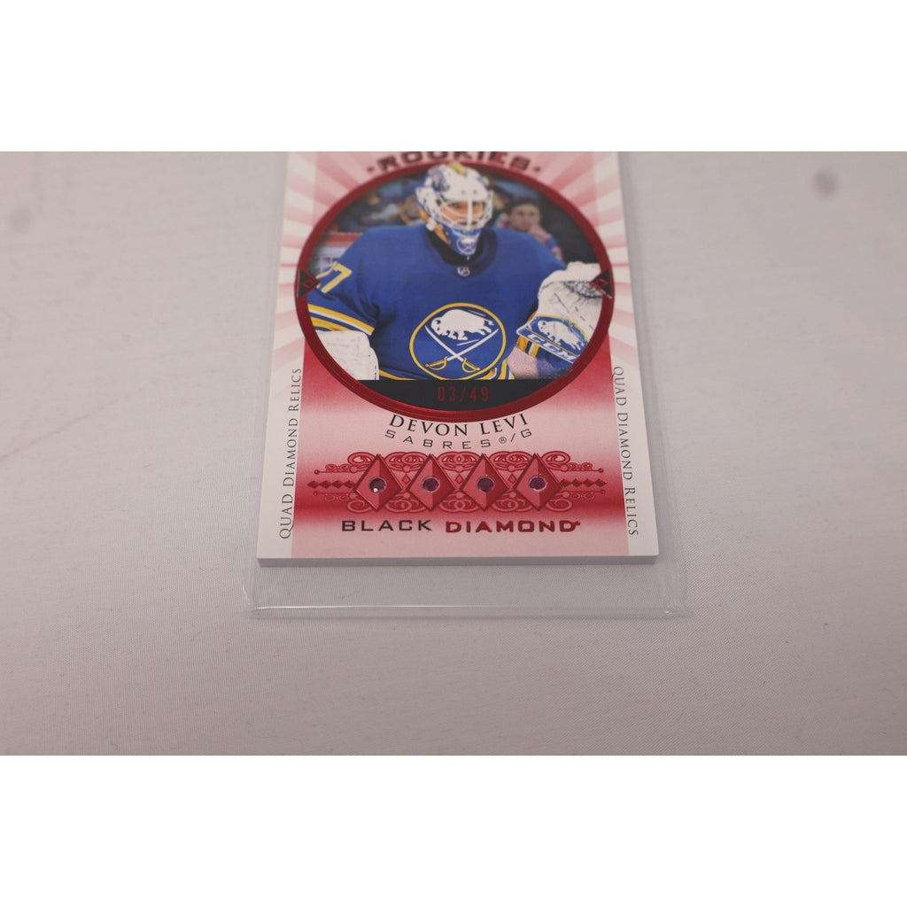 Close-up of Devon Levi Buffalo Sabres Rookie Quad Gems Relics Ruby insert card from Upper Deck Black Diamond