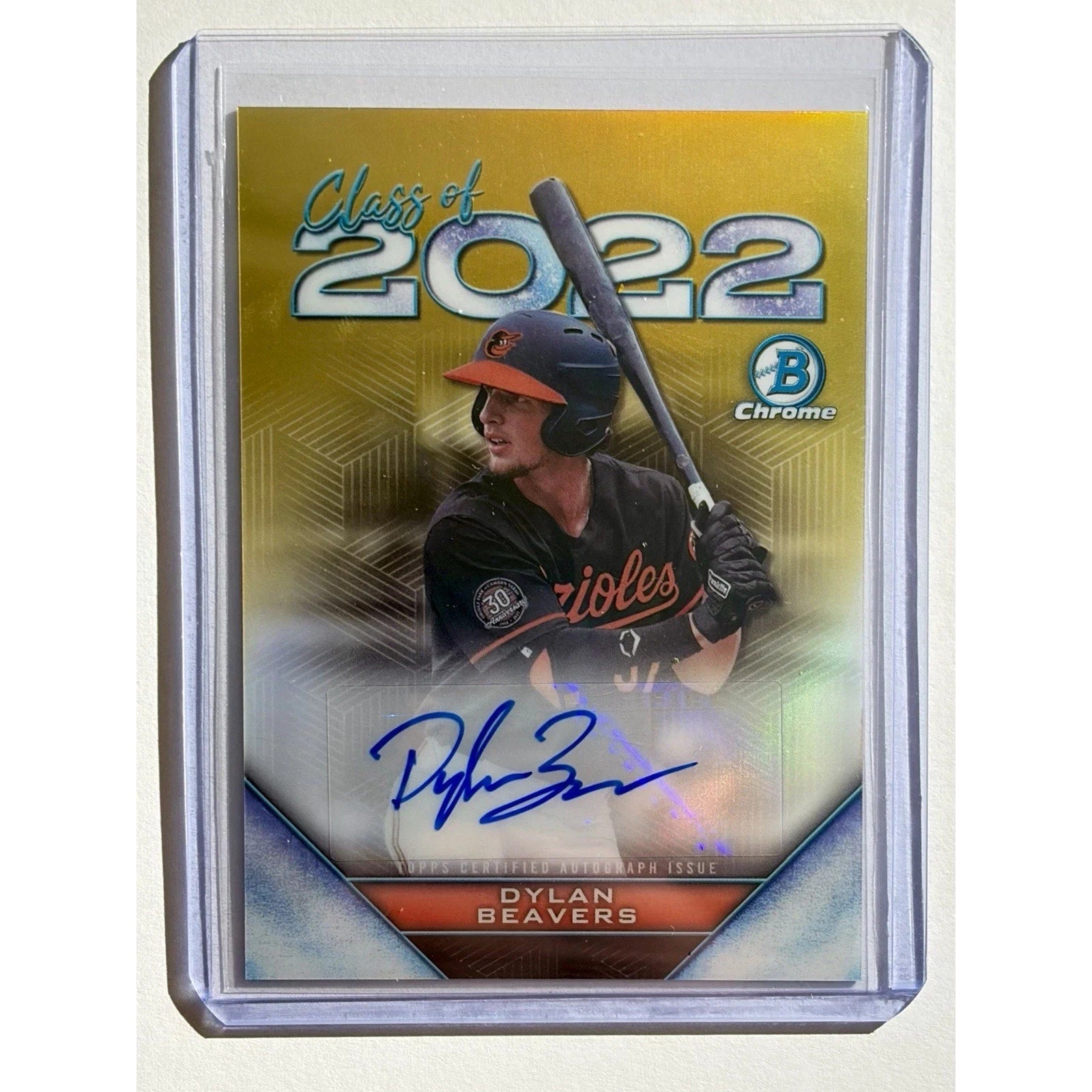 Baseball trading card featuring a player with a bat, 'Class of 2022' text, and a brand logo on a reflective surface.
