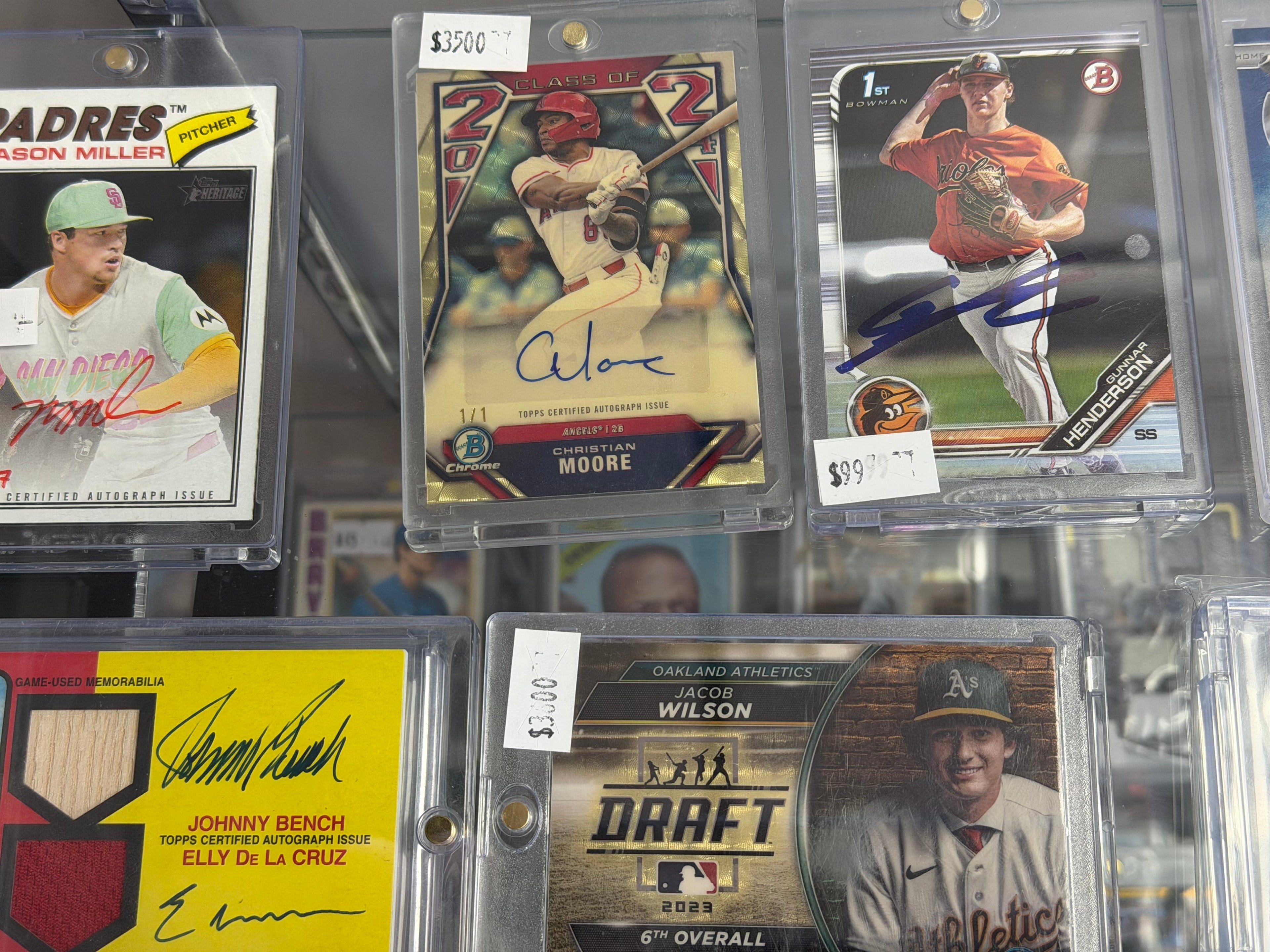 Collection of baseball trading cards in protective cases with visible autographs and player images.