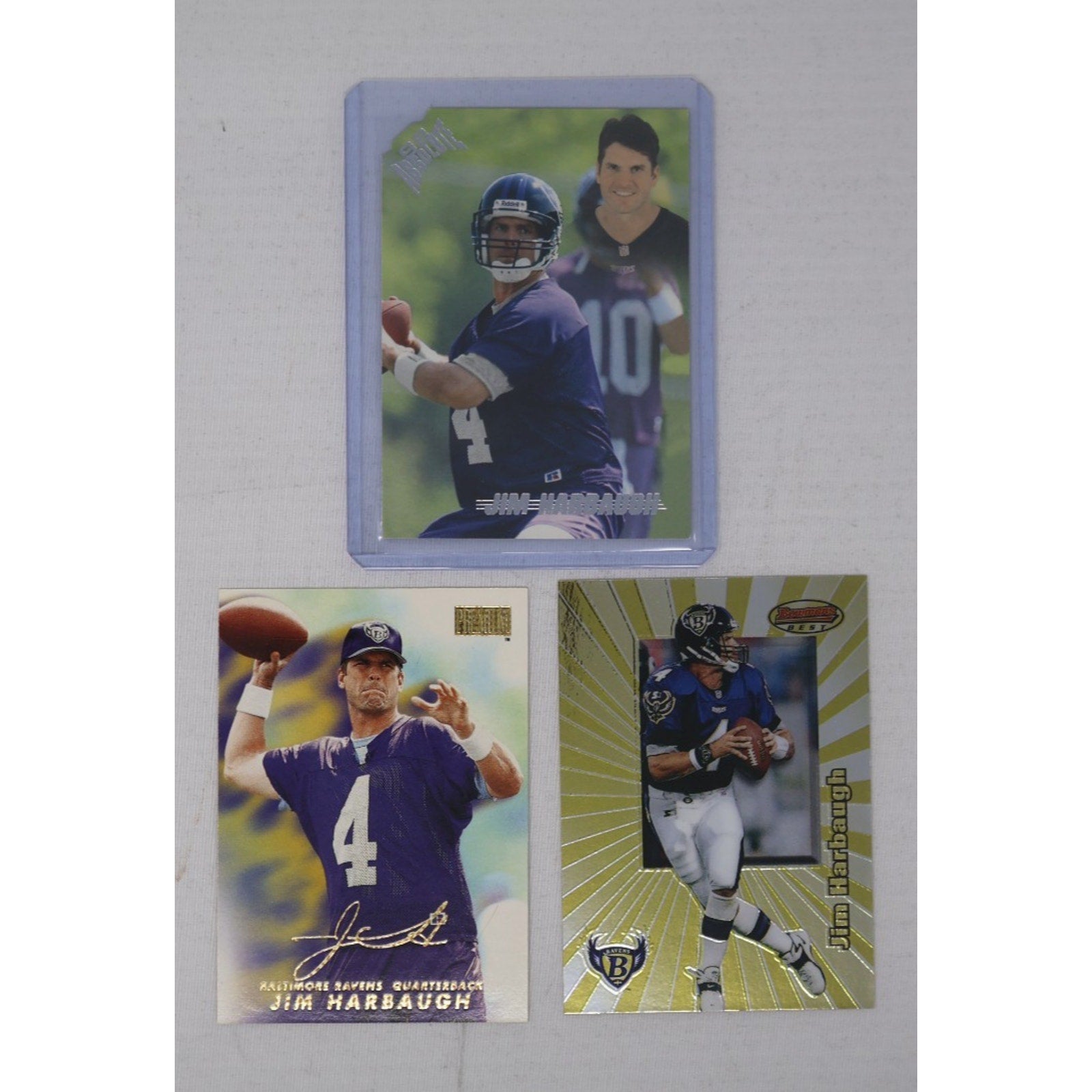 Three Jim Harbaugh Baltimore Ravens insert trading cards displayed together, including vintage Ravens quarterback-era inserts in Near Mint condition