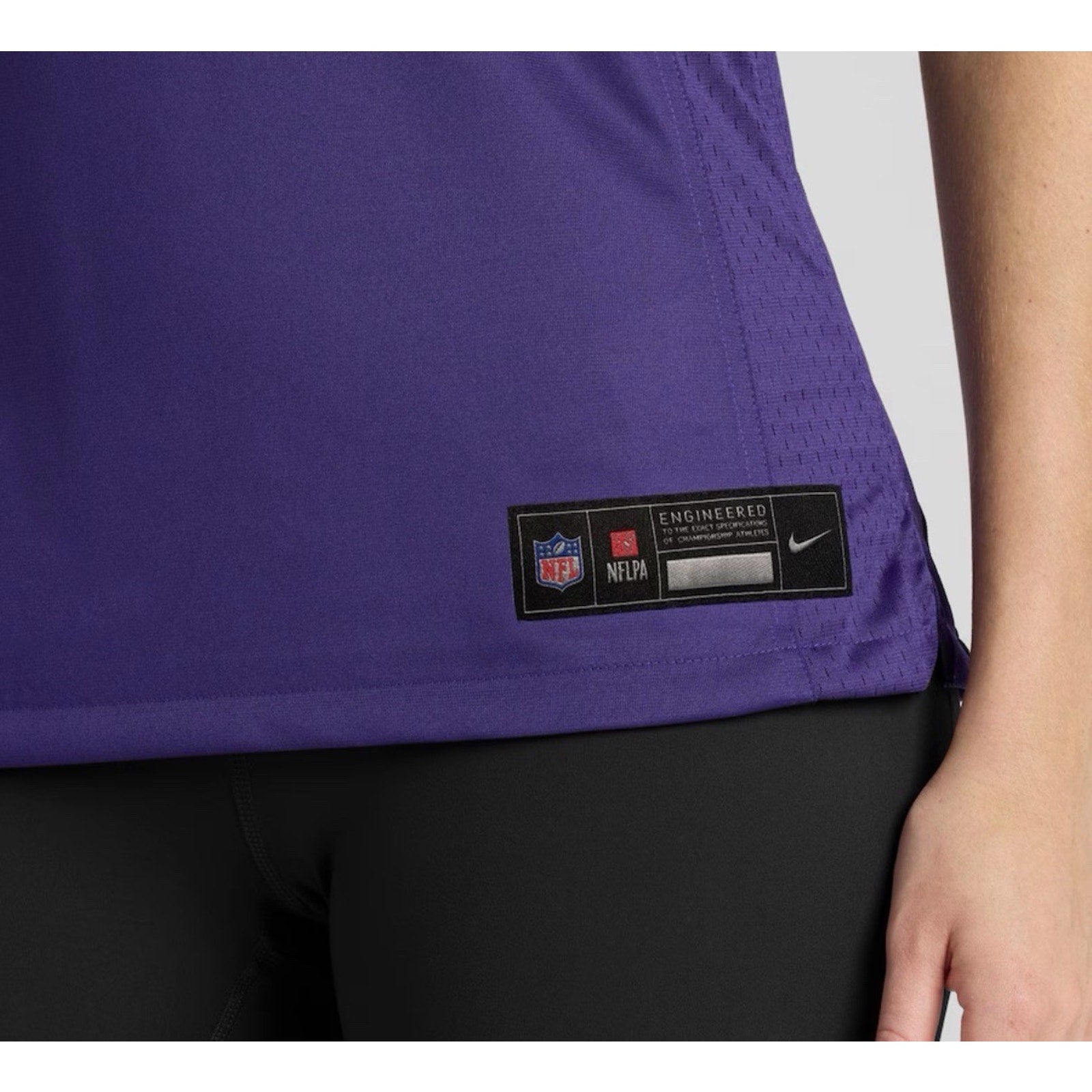Close-up detail of Nike NFL jersey lower front tag and stitching