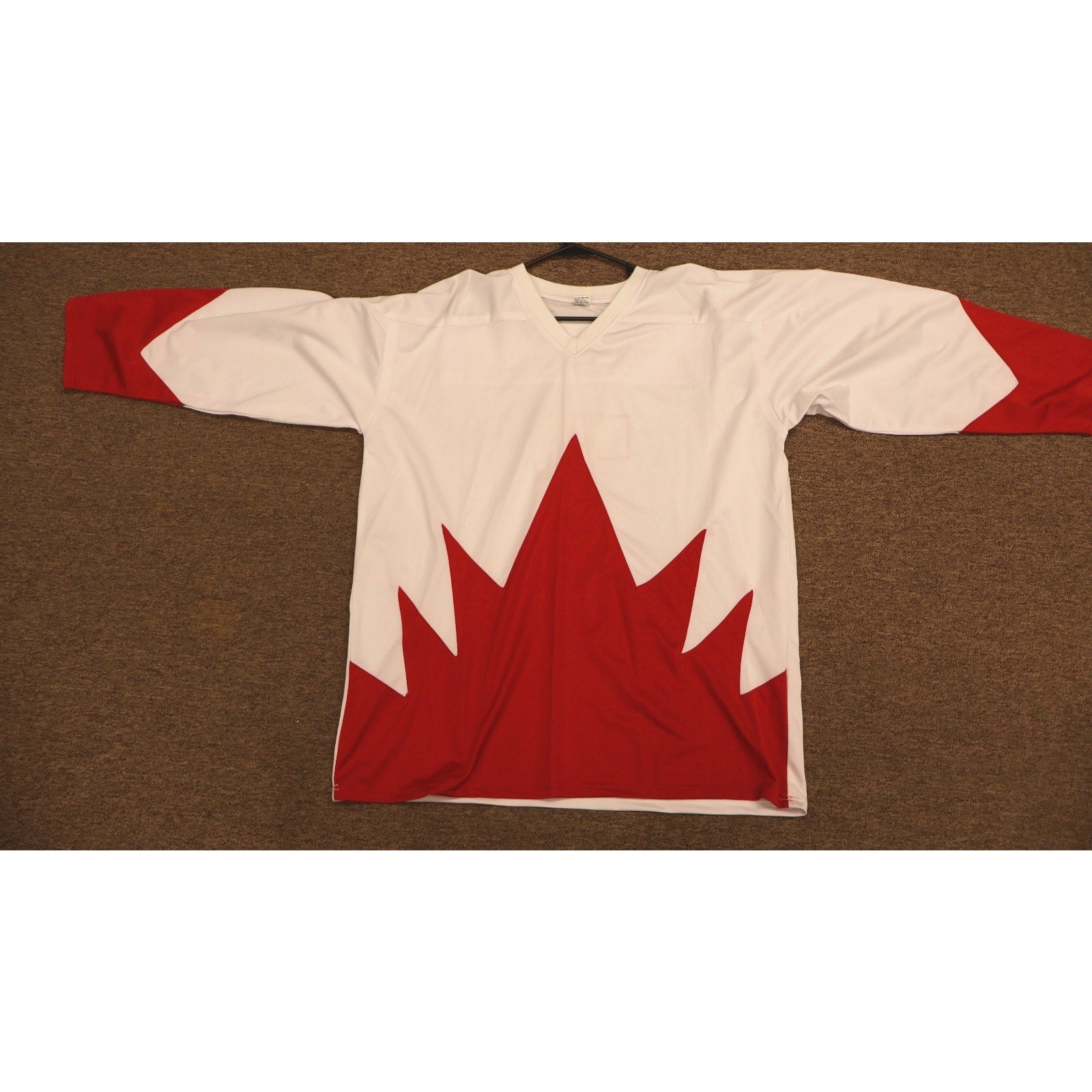 Front view of Phil Esposito Team Canada autographed hockey jersey with red maple leaf design