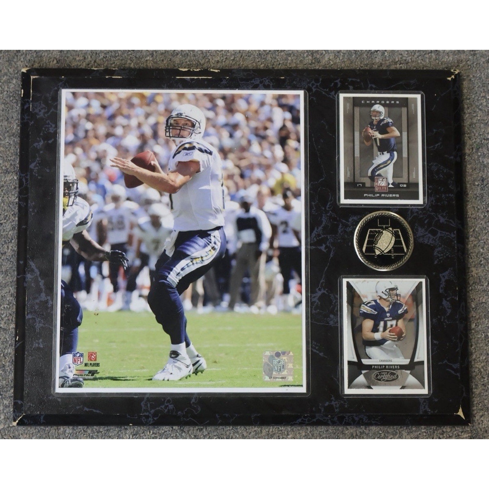 Framed sports memorabilia featuring a football player in action and related cards.