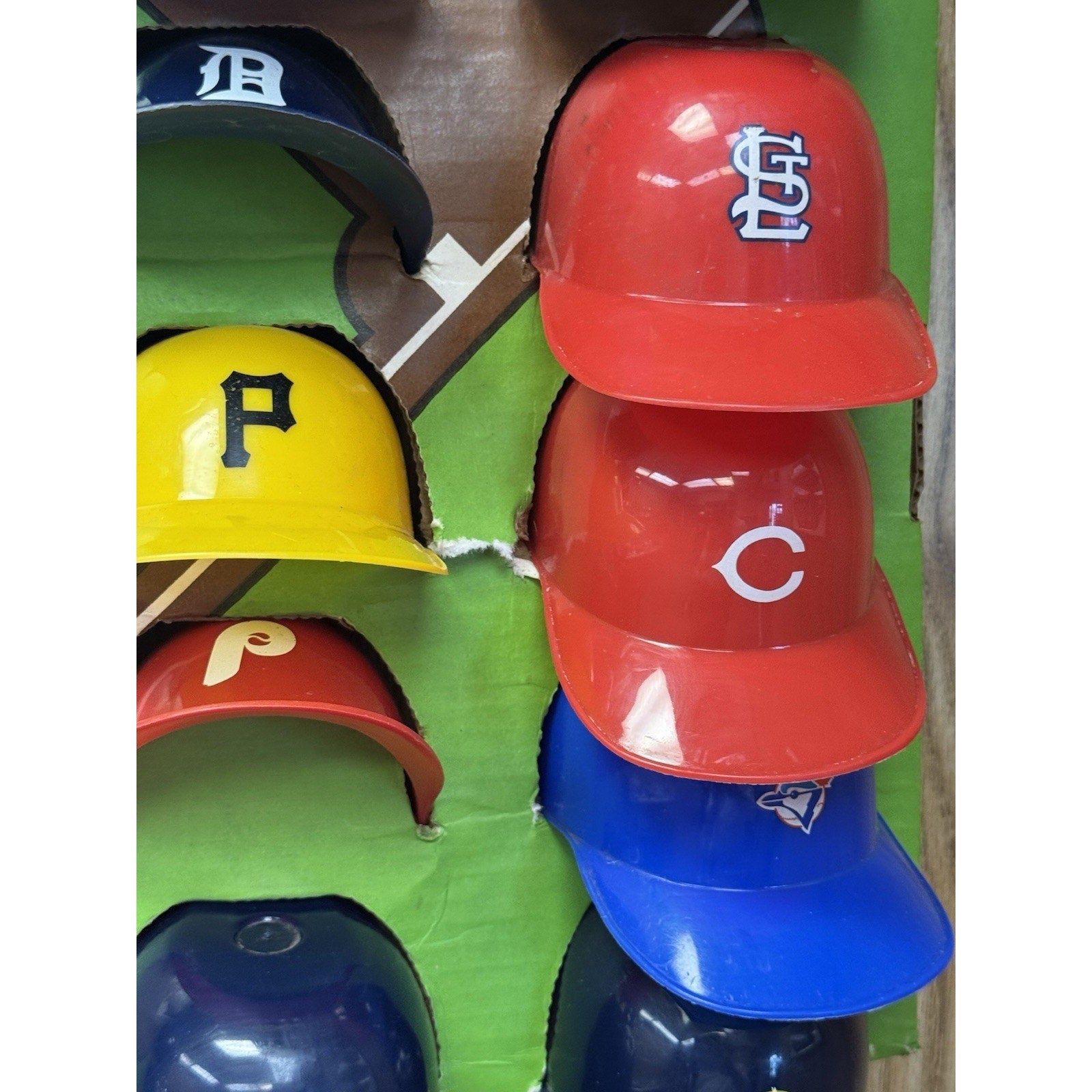 Close-up side view of vintage MLB standings board showing miniature baseball team helmet markers