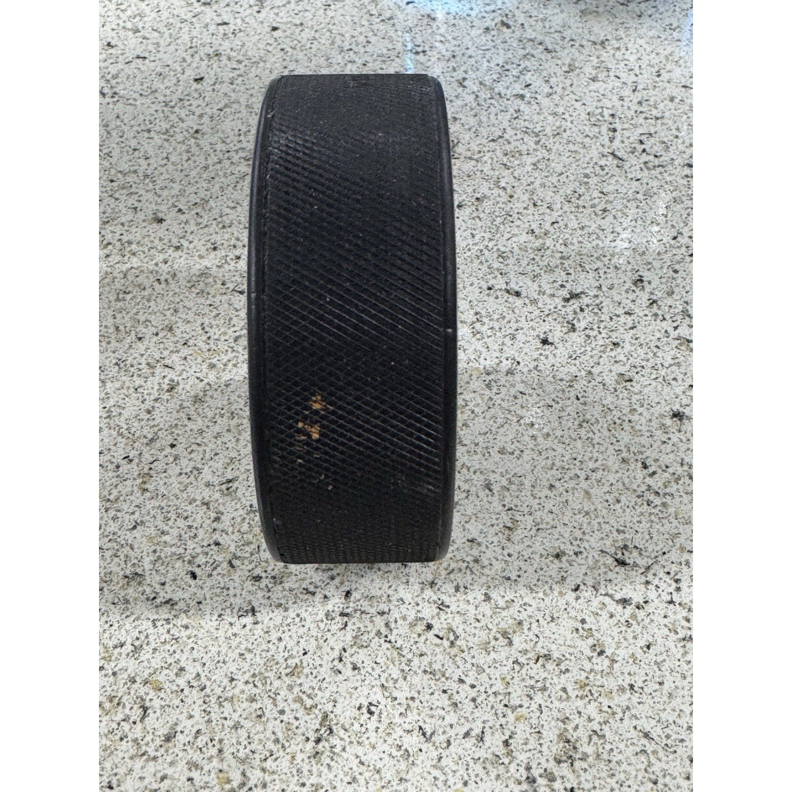 Side profile view of vintage Washington Capitals rubber hockey puck