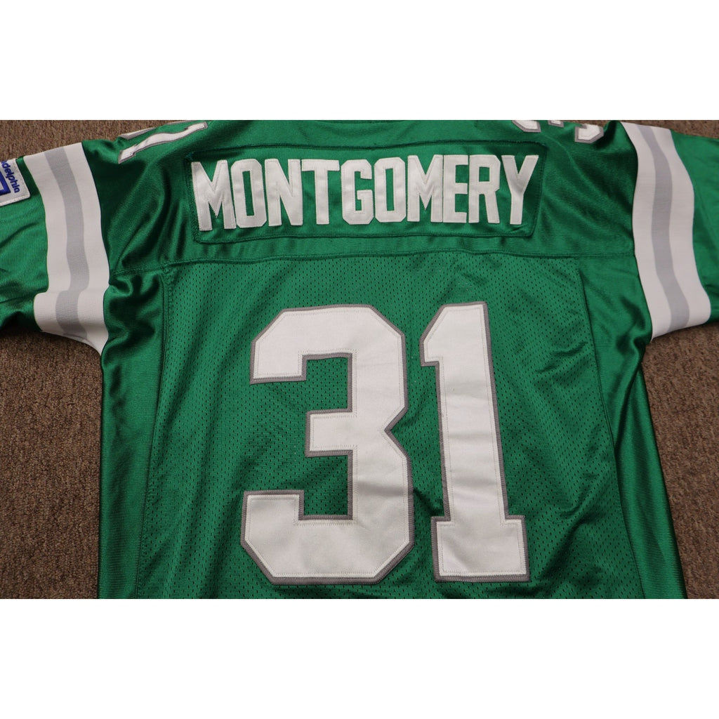 Green sports jersey with 'Montgomery' and number '31' on a brown surface