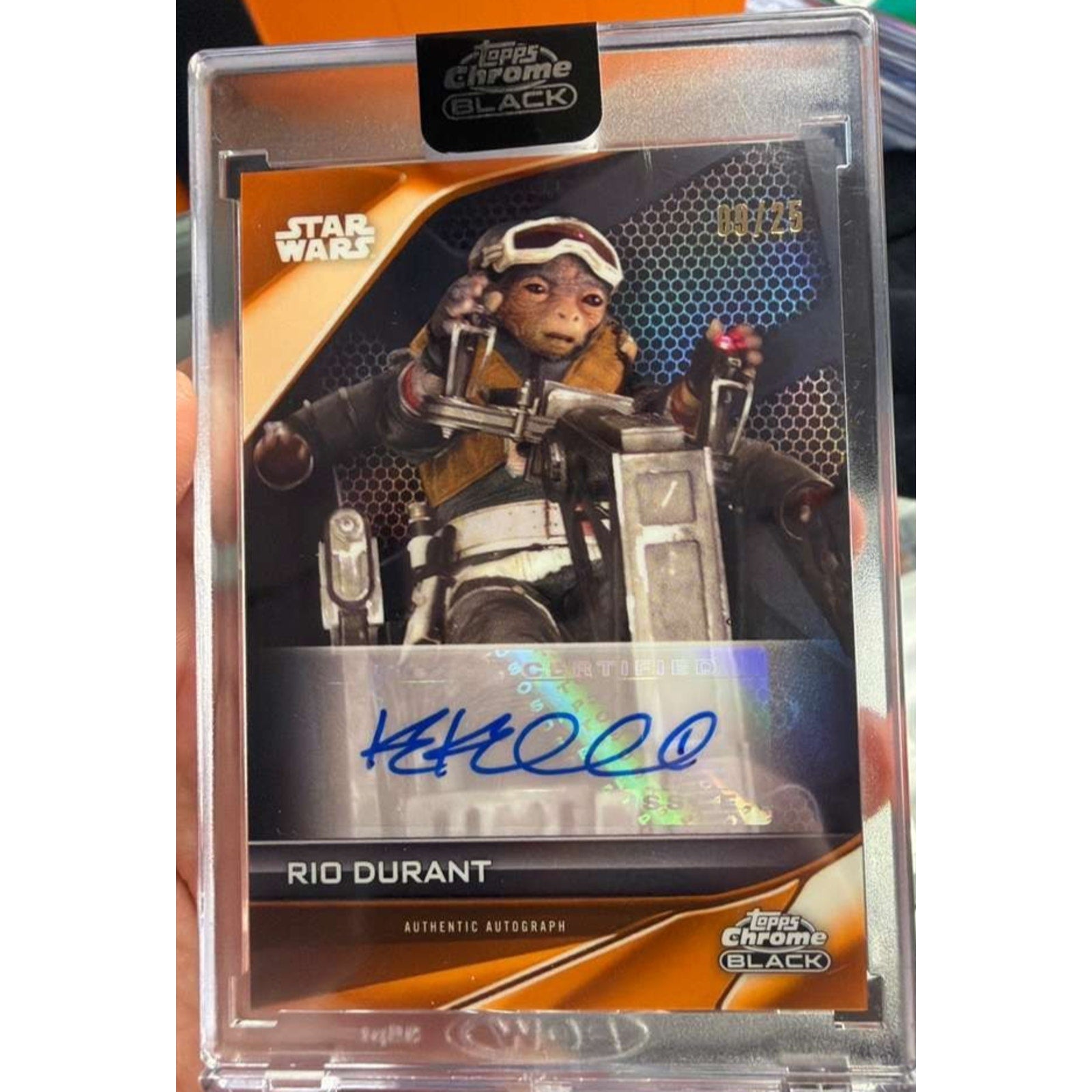 Angled front view of 2025 Topps Chrome Black Star Wars Rio Durant Orange Refractor auto card signed by Katy Kartwheel